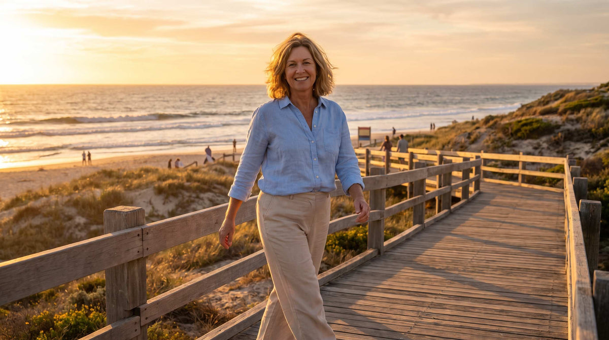 Confident Australian woman over 50 walking Perth beach boardwalk at sunset