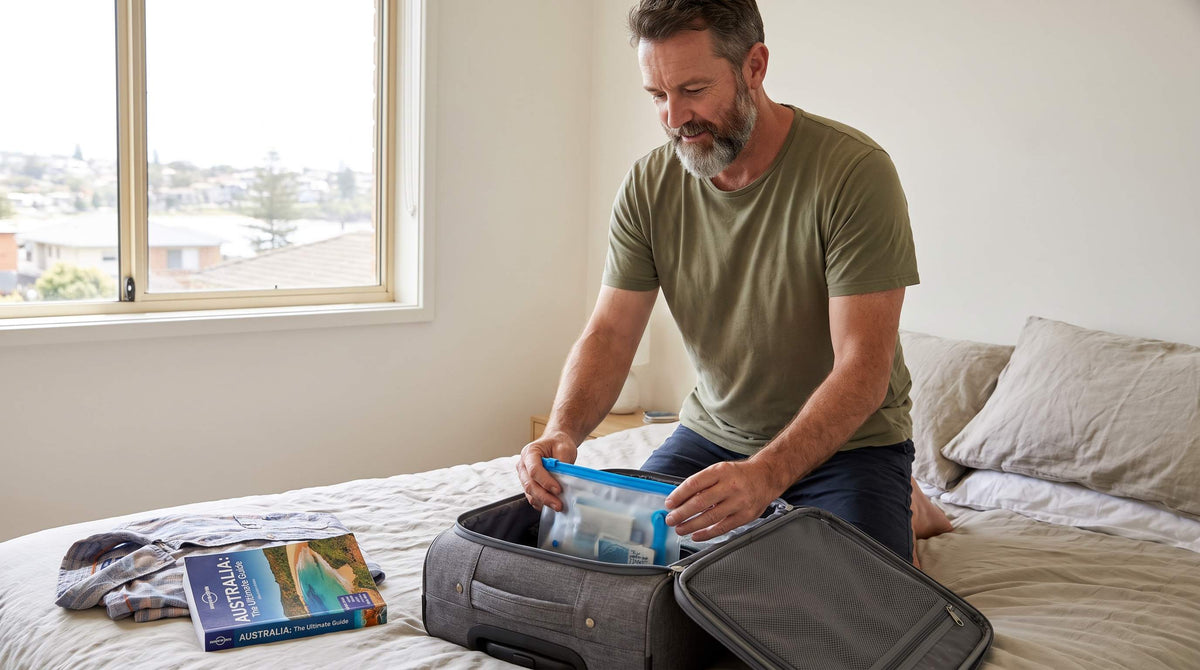 Australian man packing travel essentials including waterproof pouch for bladder leaks